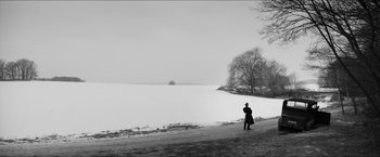Movie still from “The Captain” (2017), directed by Robert Schwentke – A person walking in the snow near a body of water; Extreme Wide shot, Low angle