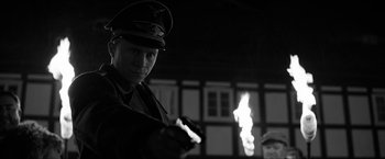 Movie still from “The Captain” (2017), directed by Robert Schwentke – A man in a military uniform holding a gun; Close Up shot, Over the shoulder angle