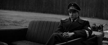 Movie still from “The Captain” (2017), directed by Robert Schwentke – A man in a military uniform sitting on a bench; Medium shot, High angle