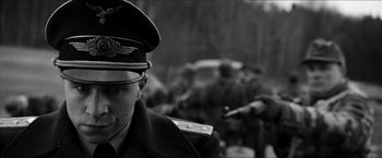 Movie still from “The Captain” (2017), directed by Robert Schwentke – A black and white photo of a man in a military uniform; Close Up shot, Over the shoulder angle