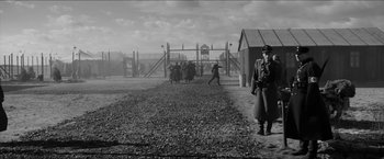 Movie still from “The Captain” (2017), directed by Robert Schwentke – A black and white photo of a group of people walking in a field; Extreme Wide shot, High angle
