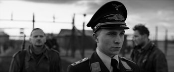 Movie still from “The Captain” (2017), directed by Robert Schwentke – A man in a military uniform is standing outside; Close Up shot, Over the shoulder angle