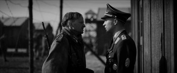 Movie still from “The Captain” (2017), directed by Robert Schwentke – A black and white photo of two men in military garb; Medium shot, Over the shoulder angle