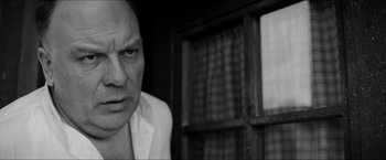Movie still from “The Captain” (2017), directed by Robert Schwentke – Black and white photograph of a man in front of a window; Close Up shot, Low angle