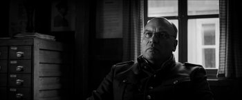 Movie still from “The Captain” (2017), directed by Robert Schwentke – Black and white photograph of a man wearing glasses; Close Up shot, Low angle