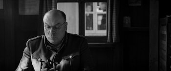 Movie still from “The Captain” (2017), directed by Robert Schwentke – An older man wearing glasses and a military jacket; Close Up shot, Over the shoulder angle