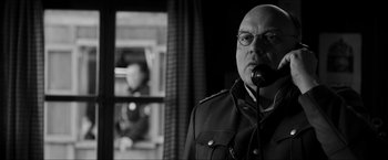 Movie still from “The Captain” (2017), directed by Robert Schwentke – A man in a military uniform talking on a phone; Close Up shot, Low angle
