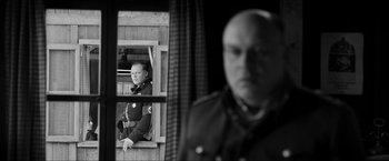 Movie still from “The Captain” (2017), directed by Robert Schwentke – A black and white photo of a man in uniform looking out of a window; Medium shot, Over the shoulder angle