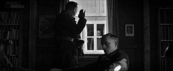 Movie still from “The Captain” (2017), directed by Robert Schwentke – Two men are looking out of a window; Medium shot, Over the shoulder angle