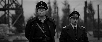 Movie still from “The Captain” (2017), directed by Robert Schwentke – Two men in military uniforms standing next to each other; Medium shot, Low angle