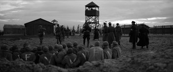 Movie still from “The Captain” (2017), directed by Robert Schwentke – A group of men standing next to each other in a field; Wide shot, High angle