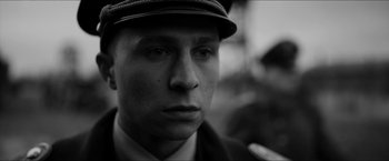 Movie still from “The Captain” (2017), directed by Robert Schwentke – A black and white photo of a man wearing a hat; Close Up shot, Low angle