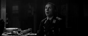 Movie still from “The Captain” (2017), directed by Robert Schwentke – A black and white photo of a man in military uniform; Close Up shot, Over the shoulder angle