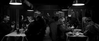 Movie still from “The Captain” (2017), directed by Robert Schwentke – A group of people sitting at tables in a room; Wide shot, High angle