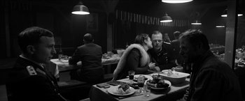 Movie still from “The Captain” (2017), directed by Robert Schwentke – A man and a woman sitting at a dinner table; Medium shot, Over the shoulder angle