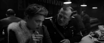 Movie still from “The Captain” (2017), directed by Robert Schwentke – A man and a woman sitting next to each other; Medium shot, Over the shoulder angle