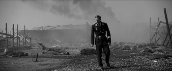 Movie still from “The Captain” (2017), directed by Robert Schwentke – A man in a military uniform walking on a rocky ground; Wide shot, Low angle