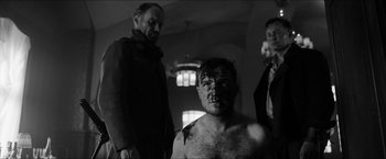Movie still from “The Captain” (2017), directed by Robert Schwentke – A man with a bruise on his face and chest; Medium shot, Over the shoulder angle