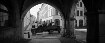 Movie still from “The Captain” (2017), directed by Robert Schwentke – An old black and white photo of a truck in the street; Wide shot, High angle