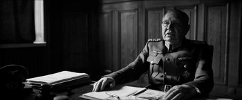 Movie still from “The Captain” (2017), directed by Robert Schwentke – An older man sitting at a desk in front of papers; Close Up shot, Over the shoulder angle