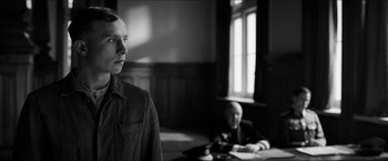 Movie still from “The Captain” (2017), directed by Robert Schwentke – A man standing in front of another man in a room; Medium shot, Over the shoulder angle