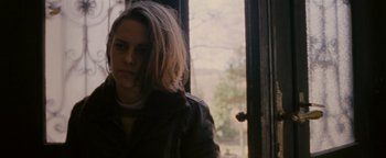 Movie still from “Personal Shopper” (2016), directed by Olivier Assayas – A woman standing in front of a window; Close Up shot, Over the shoulder angle