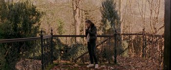 Movie still from “Personal Shopper” (2016), directed by Olivier Assayas – A woman standing in front of a metal fence; Wide shot, High angle