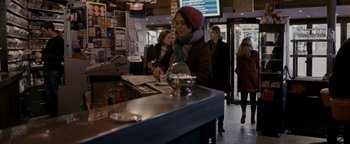 Movie still from “Personal Shopper” (2016), directed by Olivier Assayas – A woman standing at the counter of a restaurant; Medium shot, Over the shoulder angle
