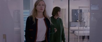 Movie still from “Personal Shopper” (2016), directed by Olivier Assayas – Two women are standing in front of a mirror in a room; Medium shot, Over the shoulder angle