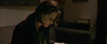 Movie still from “Personal Shopper” (2016), directed by Olivier Assayas – A woman sitting in front of an open book; Close Up shot, High angle