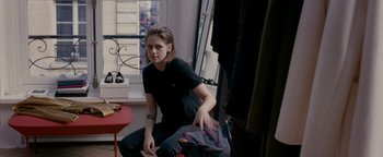 Movie still from “Personal Shopper” (2016), directed by Olivier Assayas – A woman sitting on a chair in a room; Medium shot, High angle