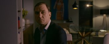 Movie still from “Personal Shopper” (2016), directed by Olivier Assayas – A person wearing a suit and tie; Medium shot, Low angle