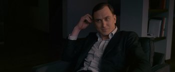 Movie still from “Personal Shopper” (2016), directed by Olivier Assayas – A man in a black suit and white dress shirt; Close Up shot, Over the shoulder angle