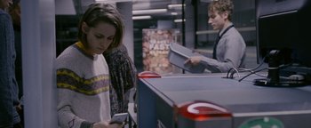 Movie still from “Personal Shopper” (2016), directed by Olivier Assayas – A woman and a man looking at their cell phones; Medium shot, Over the shoulder angle