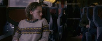 Movie still from “Personal Shopper” (2016), directed by Olivier Assayas – A woman sitting in a chair on a train; Medium shot, Over the shoulder angle