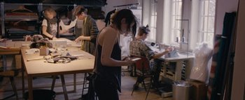 Movie still from “Personal Shopper” (2016), directed by Olivier Assayas – A group of people in a room working on papers; Medium shot, High angle