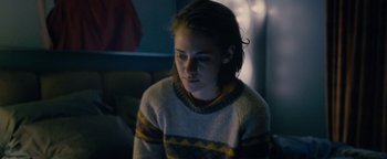 Movie still from “Personal Shopper” (2016), directed by Olivier Assayas – A young woman sitting in front of a window; Medium shot, High angle