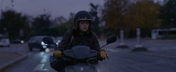 Movie still from “Personal Shopper” (2016), directed by Olivier Assayas – A person riding a motorcycle on a street; Medium shot, Over the shoulder angle