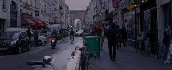 Movie still from “Personal Shopper” (2016), directed by Olivier Assayas – A busy street in a european city with people walking on the sidewalk; Wide shot, Over the shoulder angle