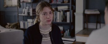 Movie still from “Personal Shopper” (2016), directed by Olivier Assayas – A young woman is sitting in front of a book shelf; Close Up shot, Over the shoulder angle