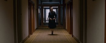 Movie still from “Personal Shopper” (2016), directed by Olivier Assayas – A woman is walking down the hall of a building; Wide shot, High angle