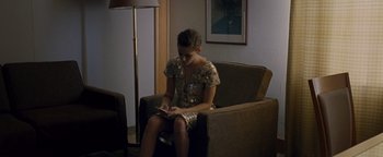 Movie still from “Personal Shopper” (2016), directed by Olivier Assayas – A woman sitting in a chair looking at her cell phone; Medium shot, High angle