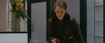 Movie still from “Personal Shopper” (2016), directed by Olivier Assayas – A woman sitting at a table looking down at her cell phone; Close Up shot, Over the shoulder angle
