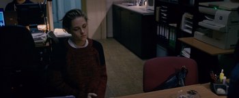 Movie still from “Personal Shopper” (2016), directed by Olivier Assayas – A woman sitting at a table in a room; Medium shot, High angle