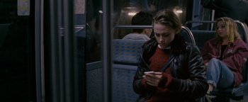Movie still from “Personal Shopper” (2016), directed by Olivier Assayas – A woman sitting on a bus looking at her phone; Medium shot, High angle