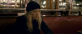 Movie still from “Personal Shopper” (2016), directed by Olivier Assayas – A woman sitting on top of a red bench; Close Up shot, High angle