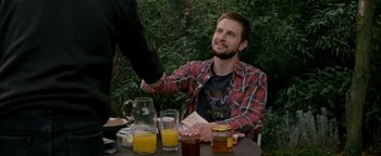 Movie still from “Personal Shopper” (2016), directed by Olivier Assayas – A man sitting at a table shaking a man's hand; Medium shot, Over the shoulder angle