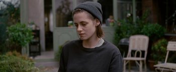 Movie still from “Personal Shopper” (2016), directed by Olivier Assayas – A woman wearing a hat and a black sweater; Close Up shot, Over the shoulder angle