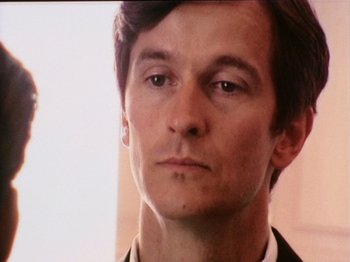 Movie still from “The Celebration” (1998), directed by Thomas Vinterberg – A person wearing a suit and tie; Close Up shot, High angle