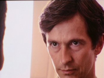 Movie still from “The Celebration” (1998), directed by Thomas Vinterberg – A man's face with a blurry background; Close Up shot, Low angle